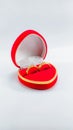 Two wedding rings in a red box in a nice love shape isolated on a white background Royalty Free Stock Photo