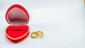 Two wedding rings in a red box in a nice love shape isolated on a white background Royalty Free Stock Photo