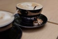 Two wedding rings on saucer with a cup of coffee on table.