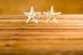 Two wedding rings with two starfish on wooden table Royalty Free Stock Photo