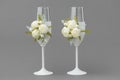 Two wedding wine glasses decorated with lace and white roses.