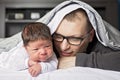 Two week newborn baby with father in bed