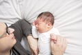 Two week newborn baby with father in bed