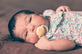 Two weeks old newborn baby girl lying down with a pacifier Royalty Free Stock Photo