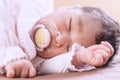 Two weeks old newborn baby girl sleeping with a pacifier Royalty Free Stock Photo