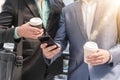 Two Westerner Business men talk and use smartphone with paper cu Royalty Free Stock Photo