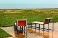 Two wet chairs on empty beach at rainy day in Batumi, Georgia Royalty Free Stock Photo