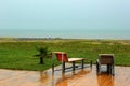 Two wet chairs on empty beach at rainy day in Batumi, Georgia Royalty Free Stock Photo
