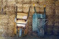 Two wheelbarrows on the hay background Royalty Free Stock Photo