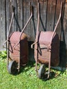 Two wheelbarrows at wooden barn