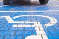 Two wheels on the disabled dedicated parking place marked with blue wheel chair symbol Royalty Free Stock Photo