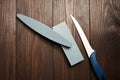 Two whetstones and steel knife, top view. Grindstones. Oval and rectangular sharpening stone on wooden table