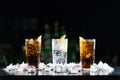 Two whisky and coke cocktails and one white alcoholic drink on the bar table. Royalty Free Stock Photo