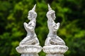 Two white angel statues, blurred background, green nature forest, religious beliefs in Buddhist temples Royalty Free Stock Photo