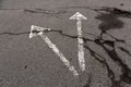 Two white arrows on cracked asphalt texture. Royalty Free Stock Photo