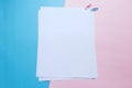 Two white blank papers and clips on pink and blue background Royalty Free Stock Photo
