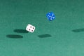 Two white and blue dices falling on a green table Royalty Free Stock Photo