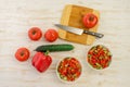 Two white bowls with fresh salad of green cucumbers, red tomatoes and bell peppers on light wooden surface. Vegetables. Lowcalorie Royalty Free Stock Photo