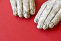 Two white broken hands of a stone statue