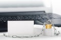 Two white business cards on PC background, lock, chain. Protection of business and finance. Protection of personal information and