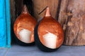 Two white candles on the shelf in spheric bronze shells.