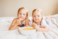 two white Caucasian children girls eating corn puffs