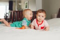 two white Caucasian cute adorable funny baby boys lying together on bed communicating and playing Royalty Free Stock Photo