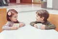 Two white Caucasian cute adorable funny children drinking talking