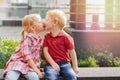 Two white Caucasian cute adorable funny children toddlers sitting together kissing each other