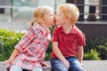 Two white Caucasian cute adorable funny children toddlers sitting together kissing each other