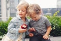 Two white Caucasian cute adorable funny children toddlers sitting together sharing apple food Royalty Free Stock Photo