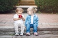 Two white Caucasian cute adorable funny children toddlers sitting together sharing eating apple food Royalty Free Stock Photo