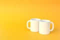 Two white ceramic cup or empty mug for coffee, drink or tea on yellow background Royalty Free Stock Photo