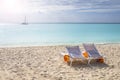 Two white chairs with orange towels on a beach Royalty Free Stock Photo