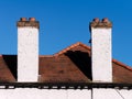 Two white chimneys on the roof against blue sky Royalty Free Stock Photo