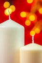 Two white christmas wax candles on red background Royalty Free Stock Photo