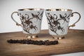 Two white cups with a pattern and coffee beans Royalty Free Stock Photo