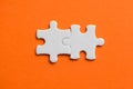 Two white details of puzzle on orange background Royalty Free Stock Photo