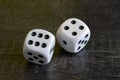 Two white dice gamble on a black background