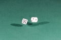 Two white dices falling on a green table Royalty Free Stock Photo