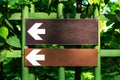 Two white directional arrow road sign point to the left in the park Royalty Free Stock Photo