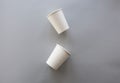 Two White Disposable Paper Cups on a Gray Background Royalty Free Stock Photo