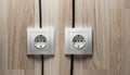 Two White Double Electrical Sockets on Light Wooden Wall with Black Cables Royalty Free Stock Photo
