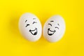 Two white eggs on yellow background concept. Emotions laughter and happiness. Royalty Free Stock Photo