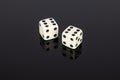 Two white gaming dice on black background