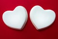Two white glossy porcelain hearts on a red background; Wedding card; A love note