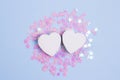 Two white heart on pastel blue background with scattered pink glitter stars. Love concept for your design Royalty Free Stock Photo