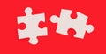 Two white jigsaw puzzle pieces with space to insert text on a red background. Copy space Royalty Free Stock Photo