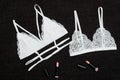 Two white lace bra and lipsticks on a black background. Fashionable concept Royalty Free Stock Photo