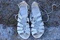 two white leather sandals shoes lie on the gray ground Royalty Free Stock Photo